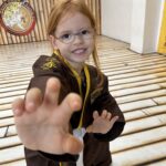 Ein lachendes Mädchen zeigt eine Kung Fu Übung, die sie im Selbstverteidigungskurs in Bamberg gelernt hat.